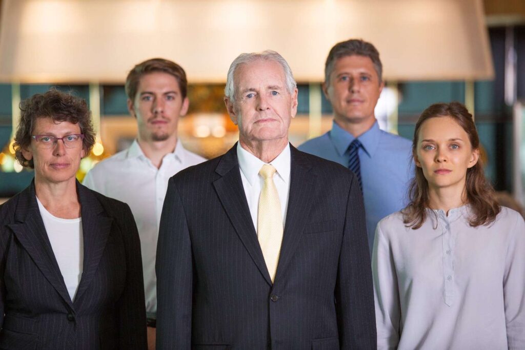Serious business team of five standing in office